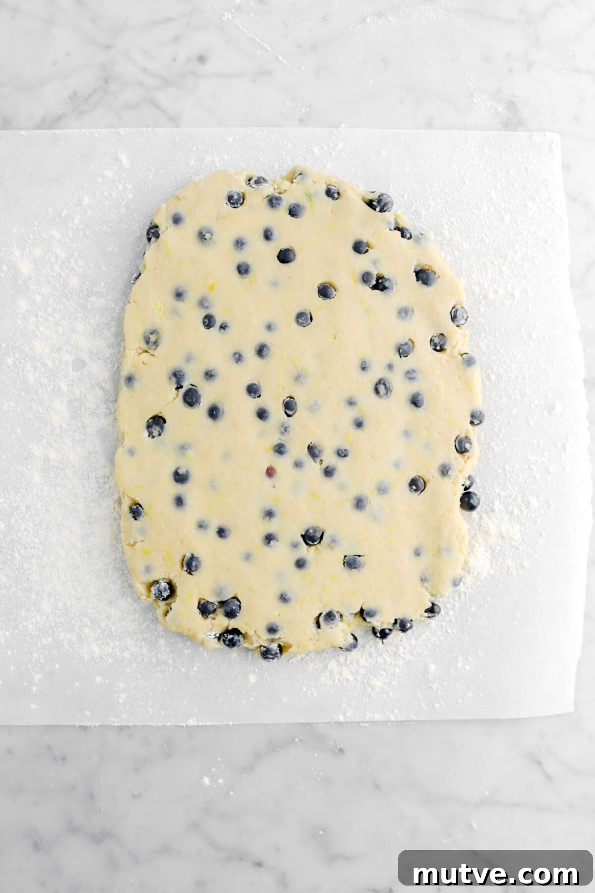 scone dough rolled out into a rectangle on floured parchment paper