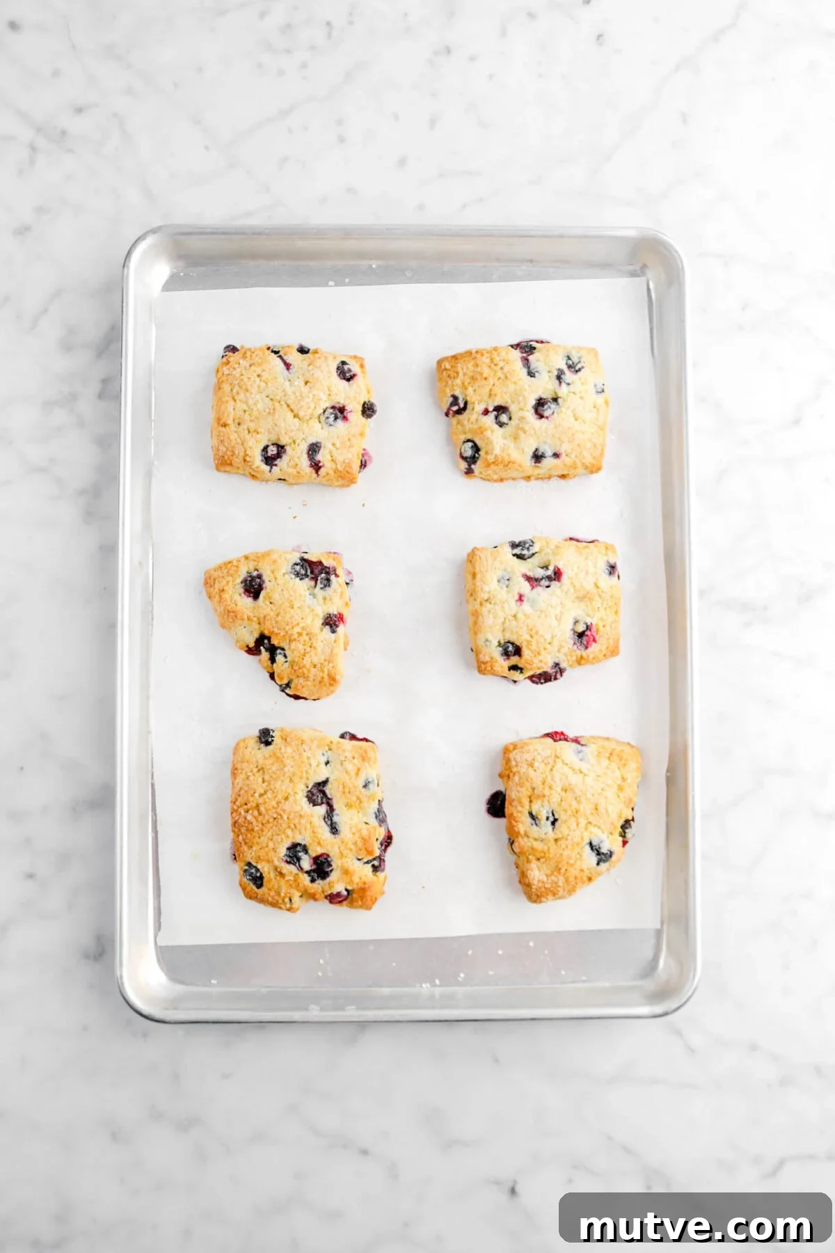 six baked scones on lined sheet pan