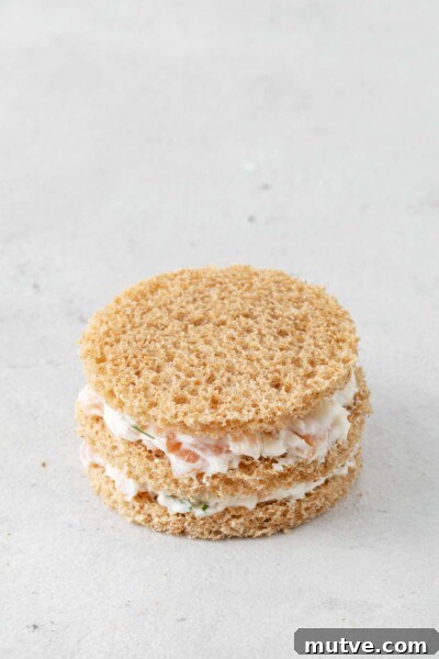 Smoked Salmon Tea Sandwiches Recipe with Cream Cheese and Dill 9 Bread cut into circles with layers of smoked salmon spread.
