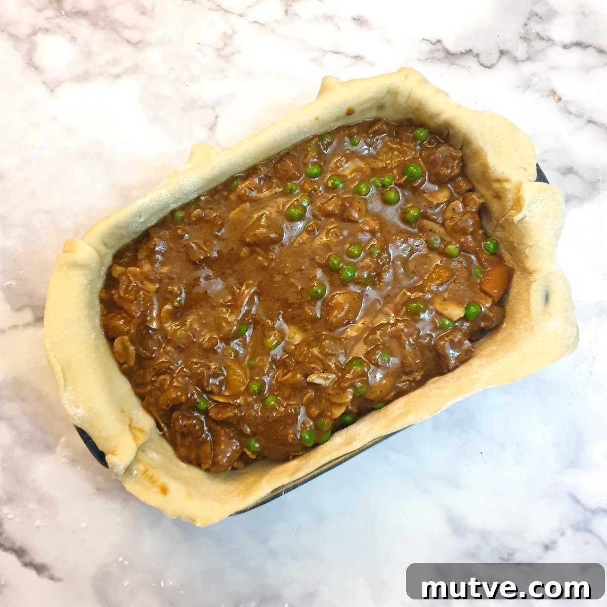 Lamb filling in a pastry-lined baking dish.