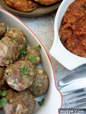 A dish of Moroccan lamb meatballs next to a dish of homemade tomato sauce.