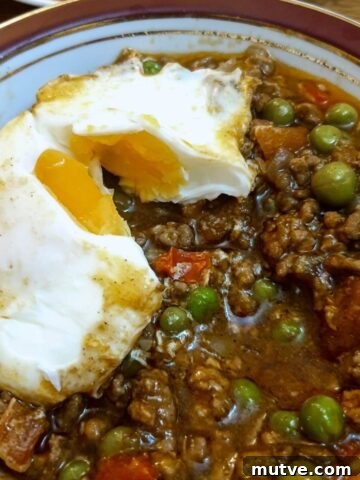 A dish of lamb keema topped with a baked egg.