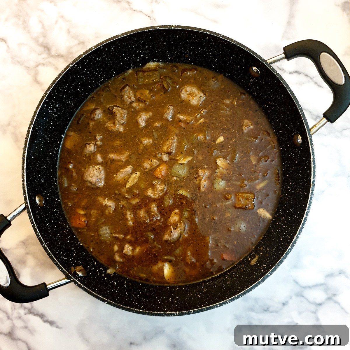 Moroccan lamb pie filling in a frying pan before being cooked.