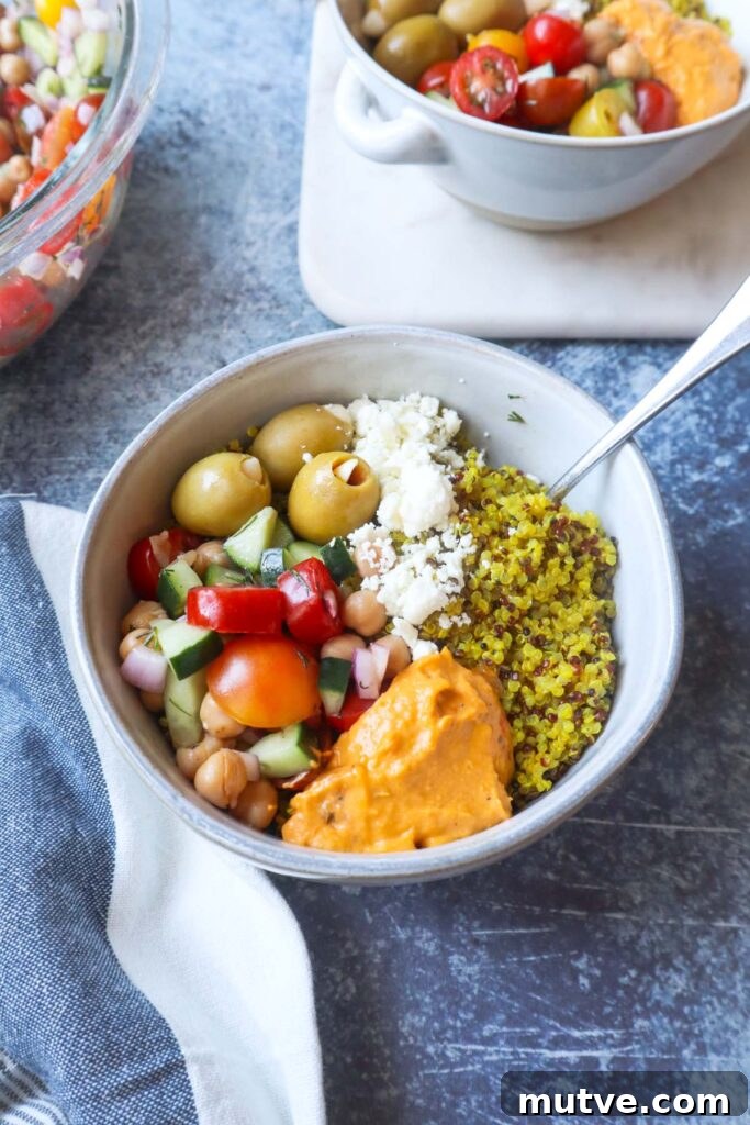 Mediterranean Power Bowl Recipe with Chickpeas and Tahini 2 white bowl with quinoa, feta, olives, hummus, and tomato cucumber salad