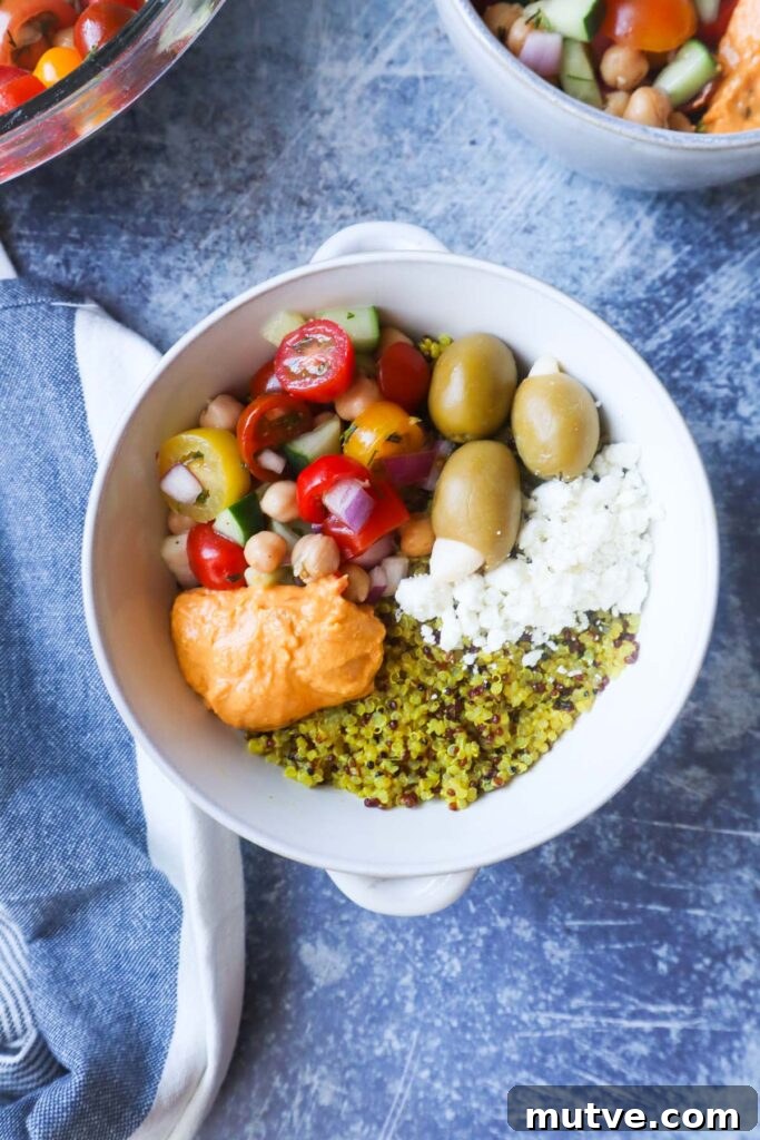 Mediterranean Power Bowl Recipe with Chickpeas and Tahini 7 white bowl with quinoa, feta, olives, hummus, and tomato cucumber salad