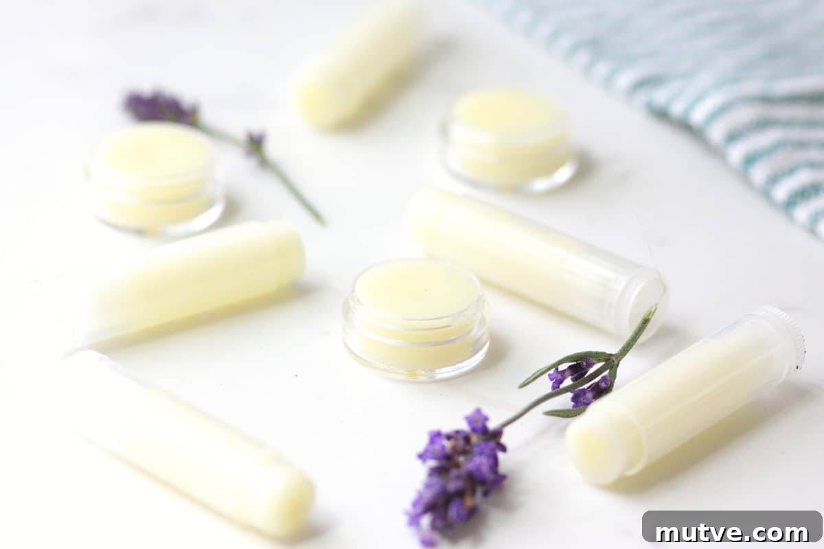 Beeswax Lip Balm Recipe: How to Make Soft, Hydrated Lips 3 a variety of beeswax lip balms laying on a white table surrounded by lavender flowers
