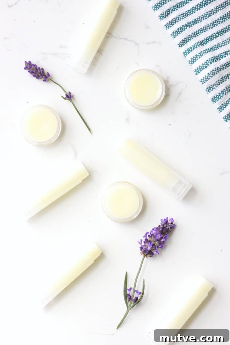 Beeswax Lip Balm Recipe: How to Make Soft, Hydrated Lips 7 a variety of beeswax lip balms laying on a white table surrounded by lavender flowers