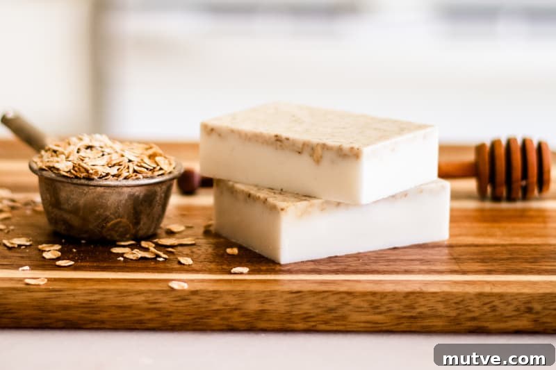 Homemade honey oatmeal soap bars on wooden cutting board.