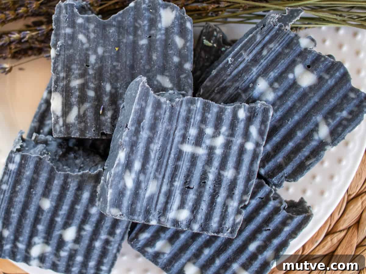Bars of charcoal soap stacked up on a wicker placemat.