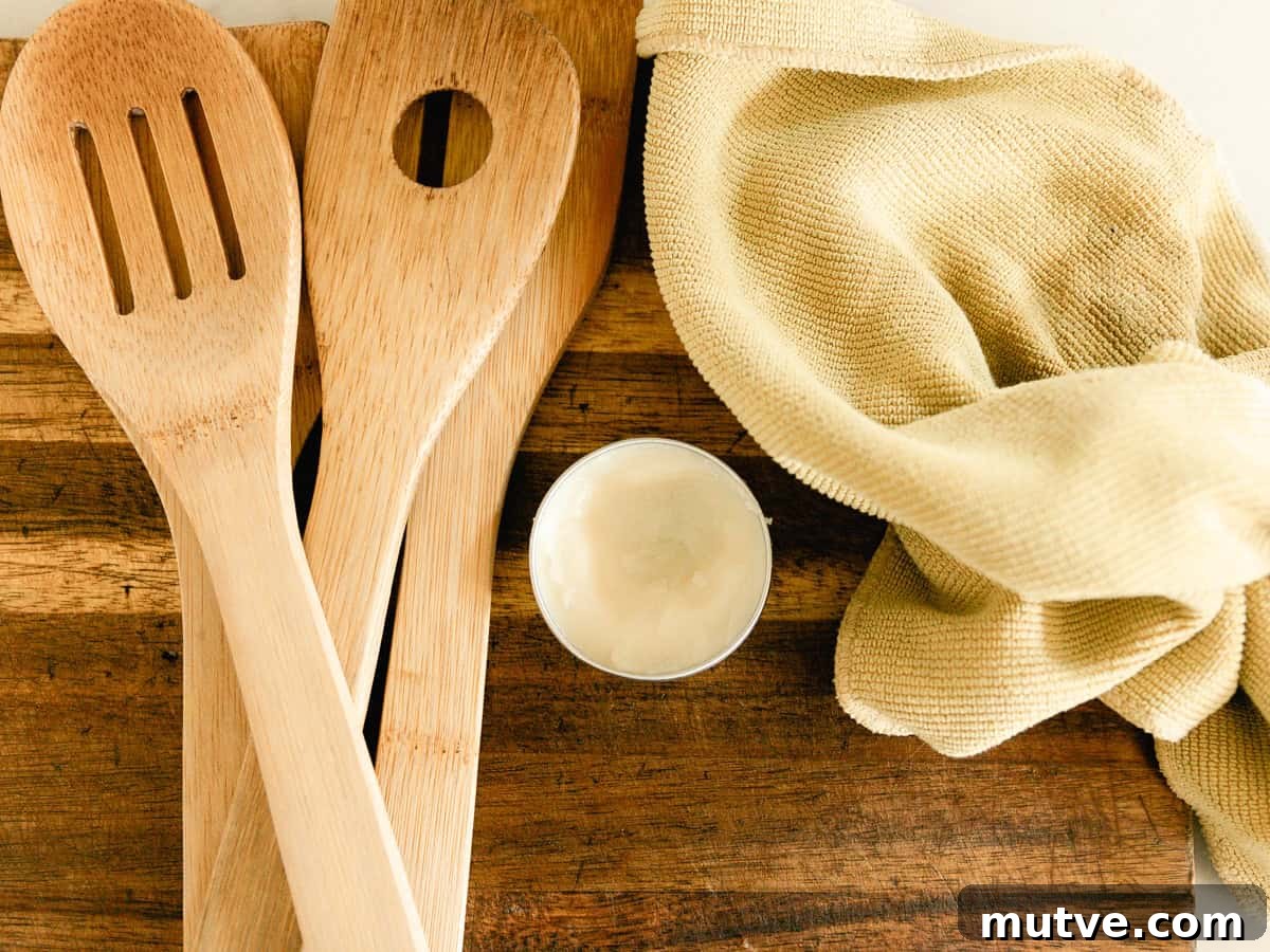 Homemade wood balm on a wooden cutting board with wooden utensils next to it.