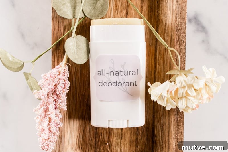 Homemade deodorant laying on a wooden tray with dried flowers. 
