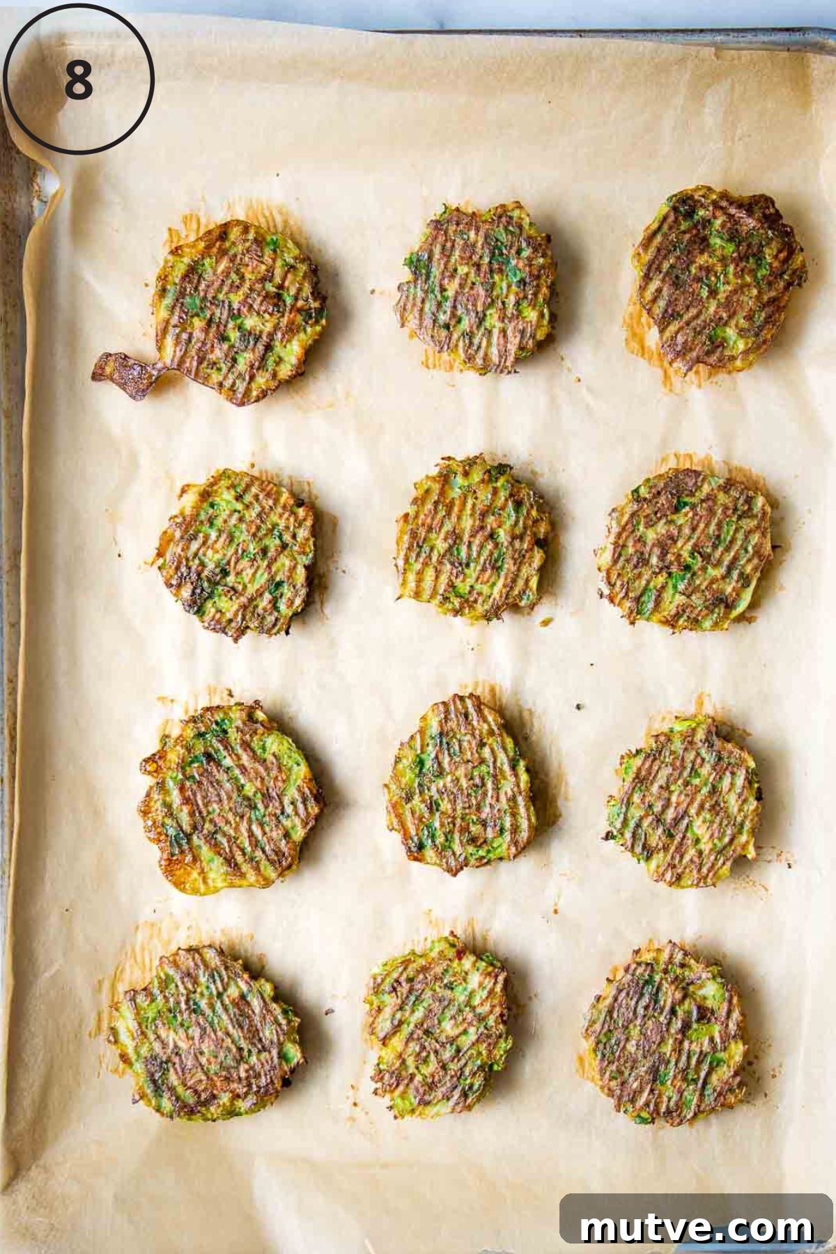 Crispy Oven Baked Brussels Sprouts Latkes 6 Crispy brussels sprouts latkes on a baking sheet lined with parchment.