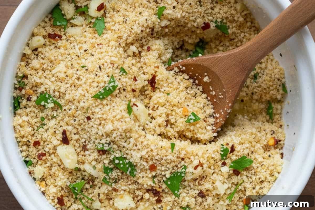 Crispy Oven-Baked Shrimp Scampi Recipe with Garlic Butter 5 Mixed Panko breadcrumbs, Parmesan cheese, red pepper flakes, garlic and some parsley with some melted butter in a small bowl.