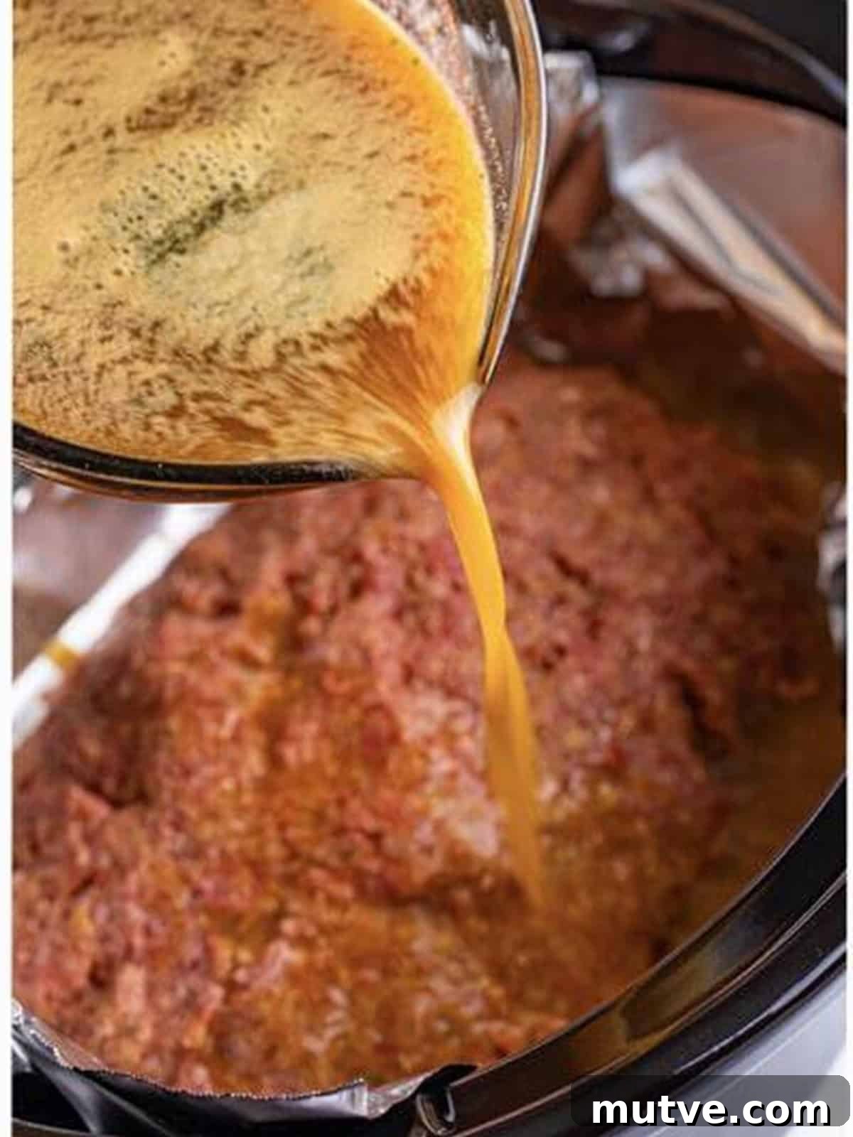 Slow Cooker Mississippi Meatloaf Recipe 11 Gravy poured over the shaped meatloaf in the slow cooker.