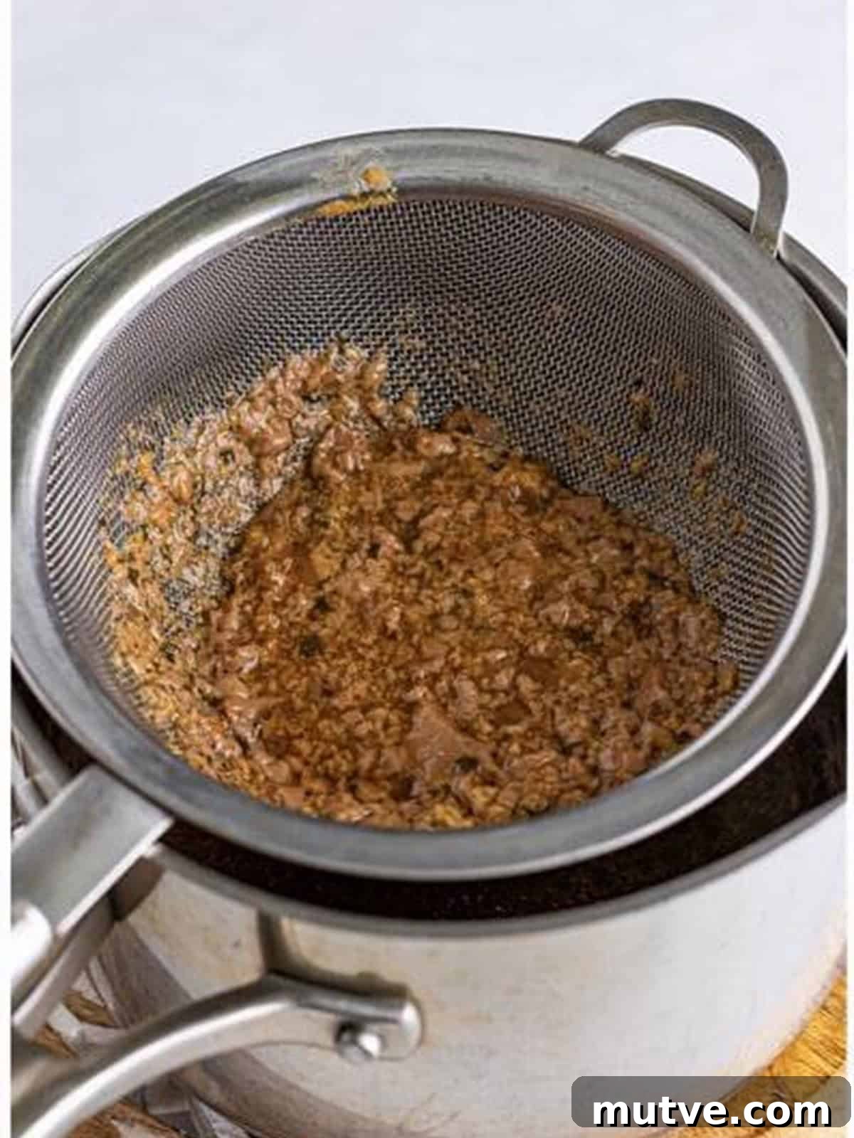Slow Cooker Mississippi Meatloaf Recipe 14 Slow cooker gravy strained through a sieve into a sauce pot.