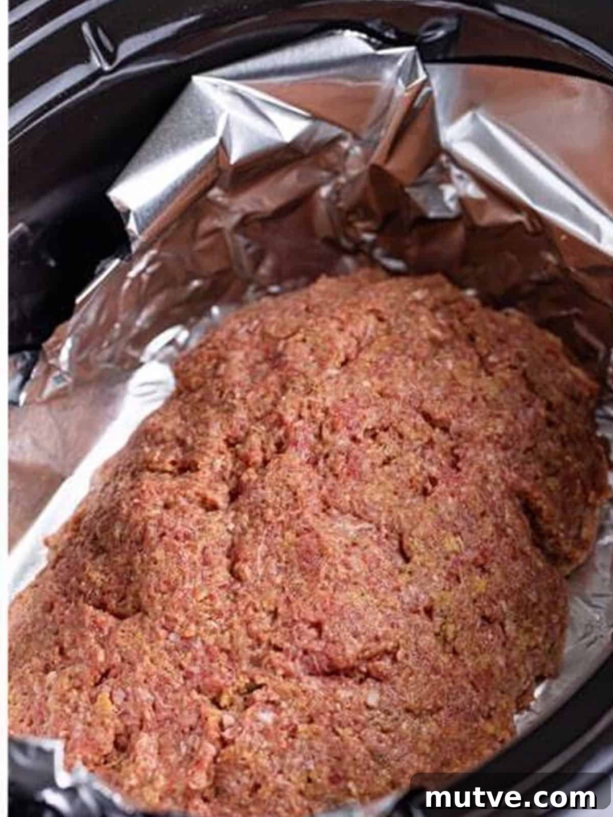 Slow Cooker Mississippi Meatloaf Recipe 9 Meatloaf shaped into an oval on foil inside the slow cooker.