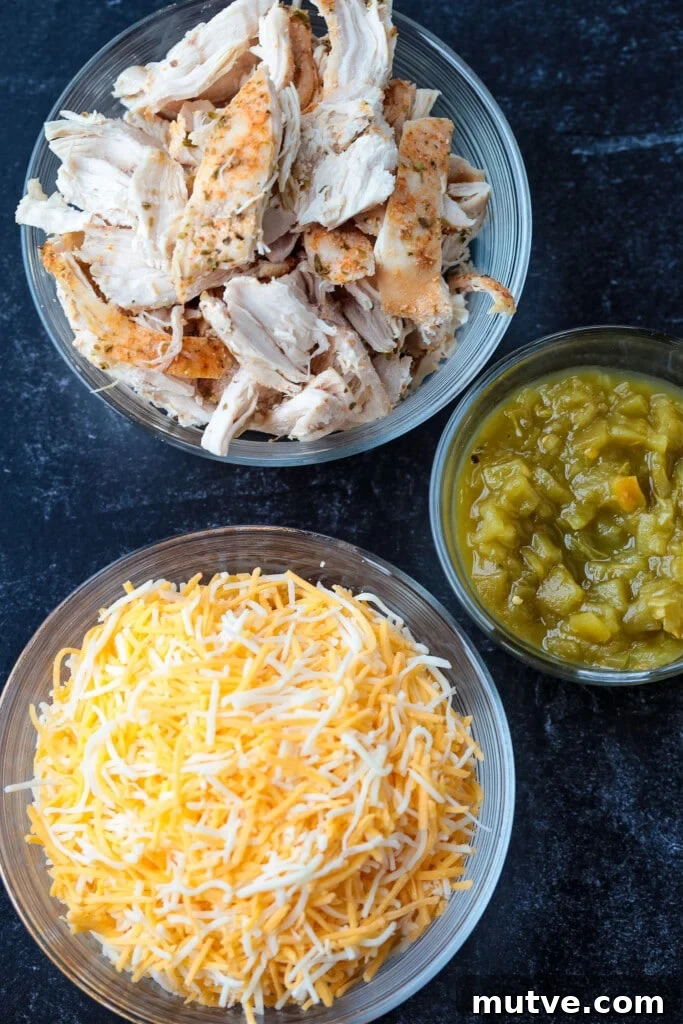 Shredded chicken, green chilis and cheese ready for quesadillas shredded chicken, green chilis and cheese on a black board