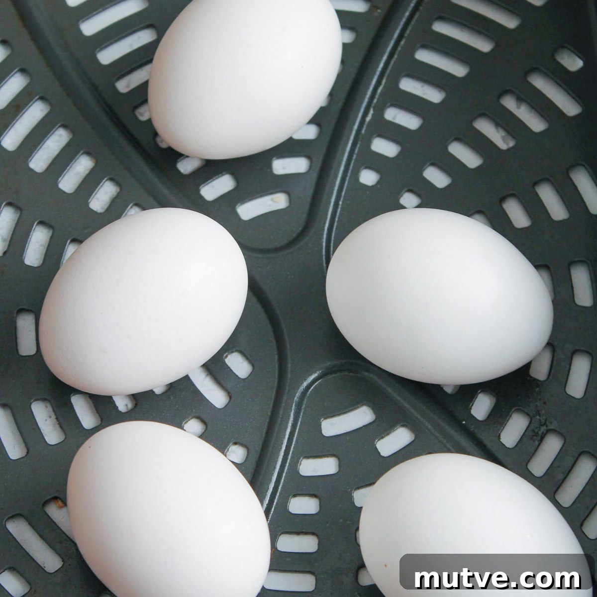 How to Make Air Fryer Eggs: Fluffy, Hands-Off Breakfast 4 Raw eggs in an air fryer basket.
