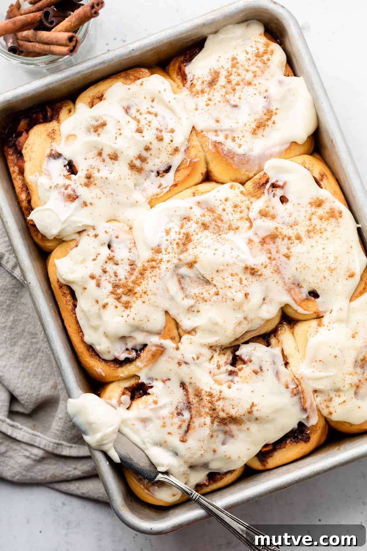 apple cinnamon rolls in pan with icing