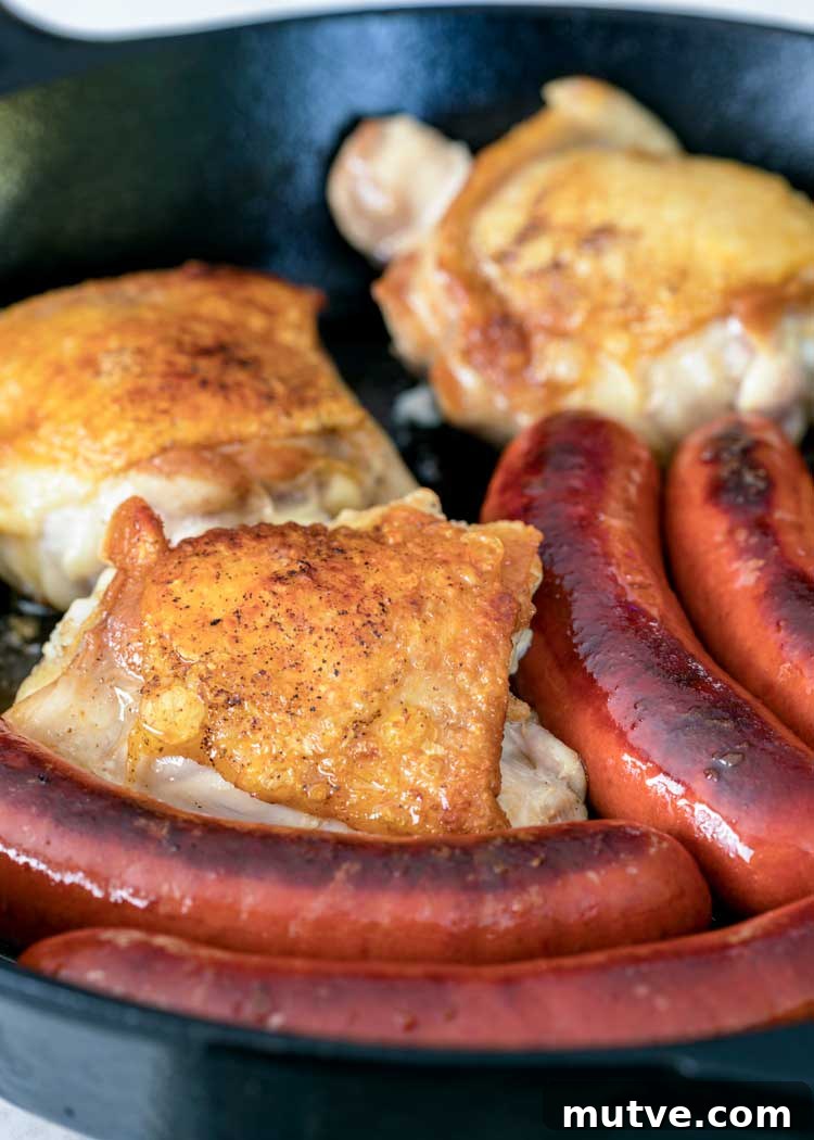 This comforting French Cassoulet recipe has juicy chicken, sausage, bacon and white beans that simmer away in a broth spiked with onion, garlic and herbs. pan fried sausages and chicken thighs