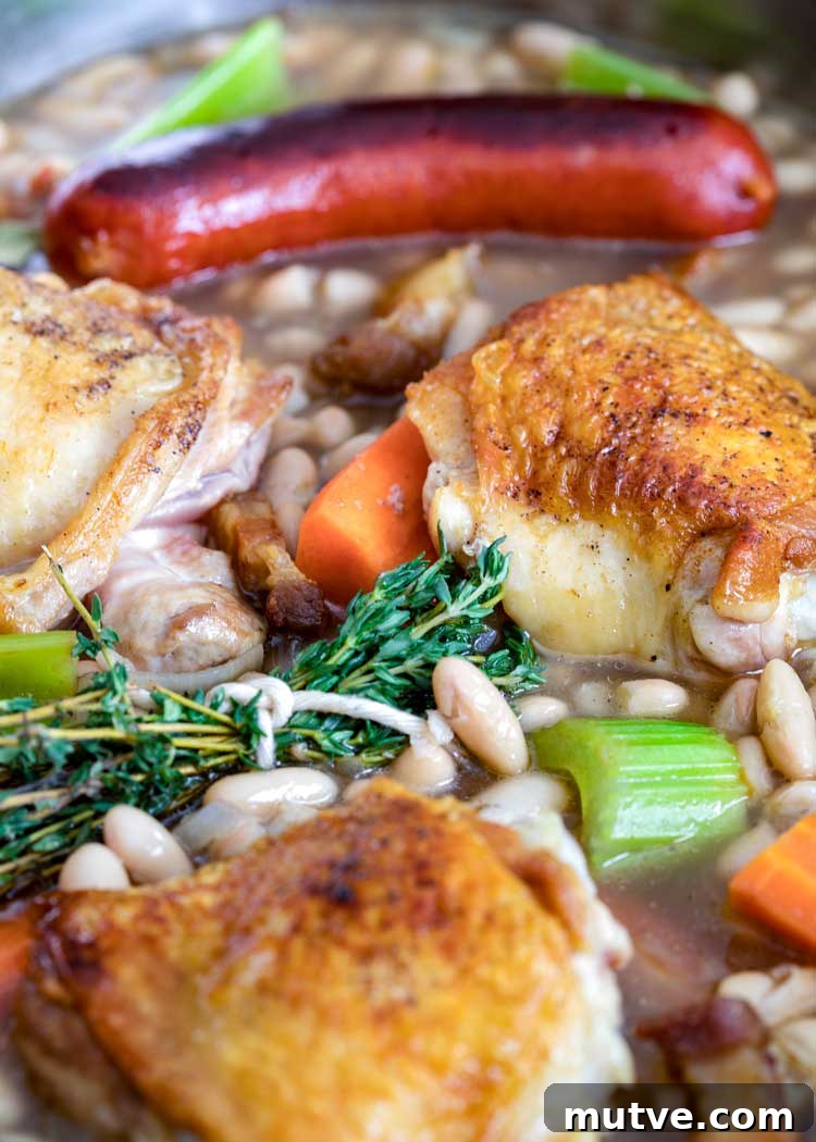 This comforting French Cassoulet recipe has juicy chicken, sausage, bacon and white beans that simmer away in a broth spiked with onion, garlic and herbs. thyme bundle with chicken and sausages