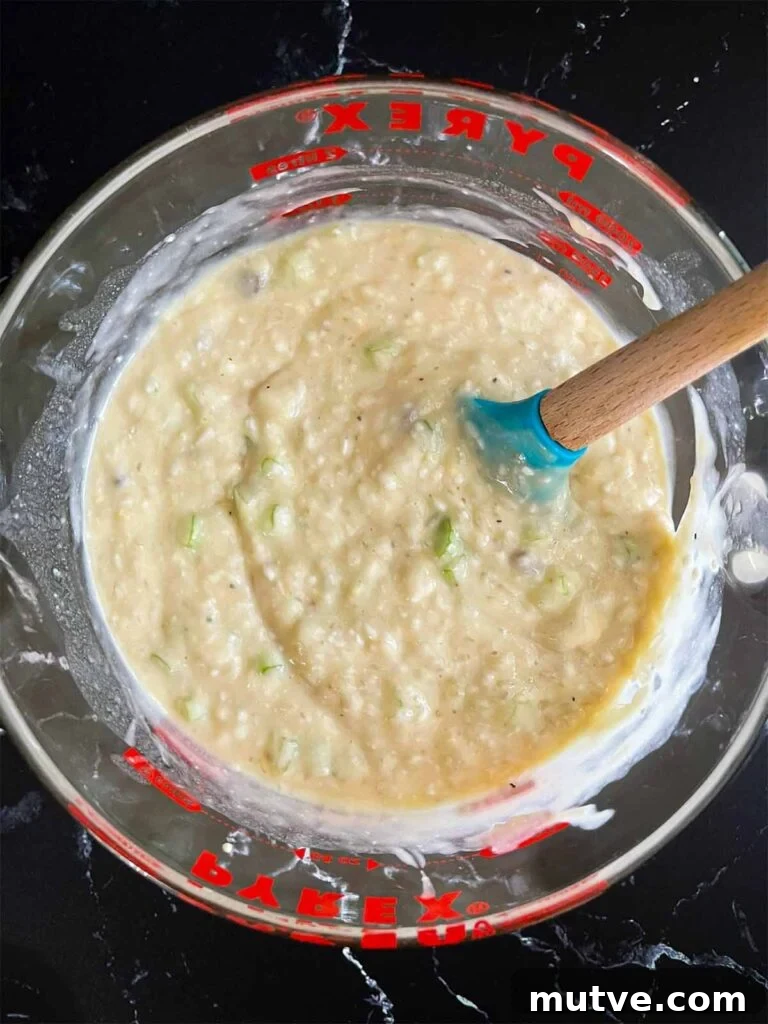 Soup, celery, and rice mixture in a large glass measuring cup.