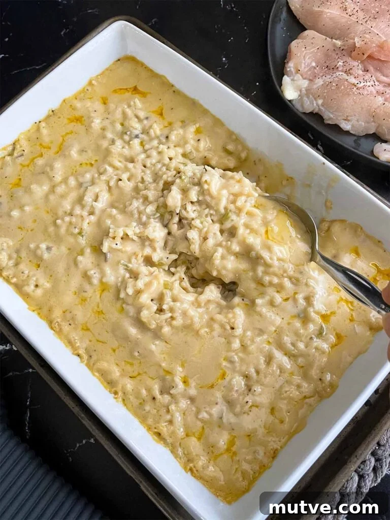 Stirring the chicken and rice casserole after baking for an hour and a half.