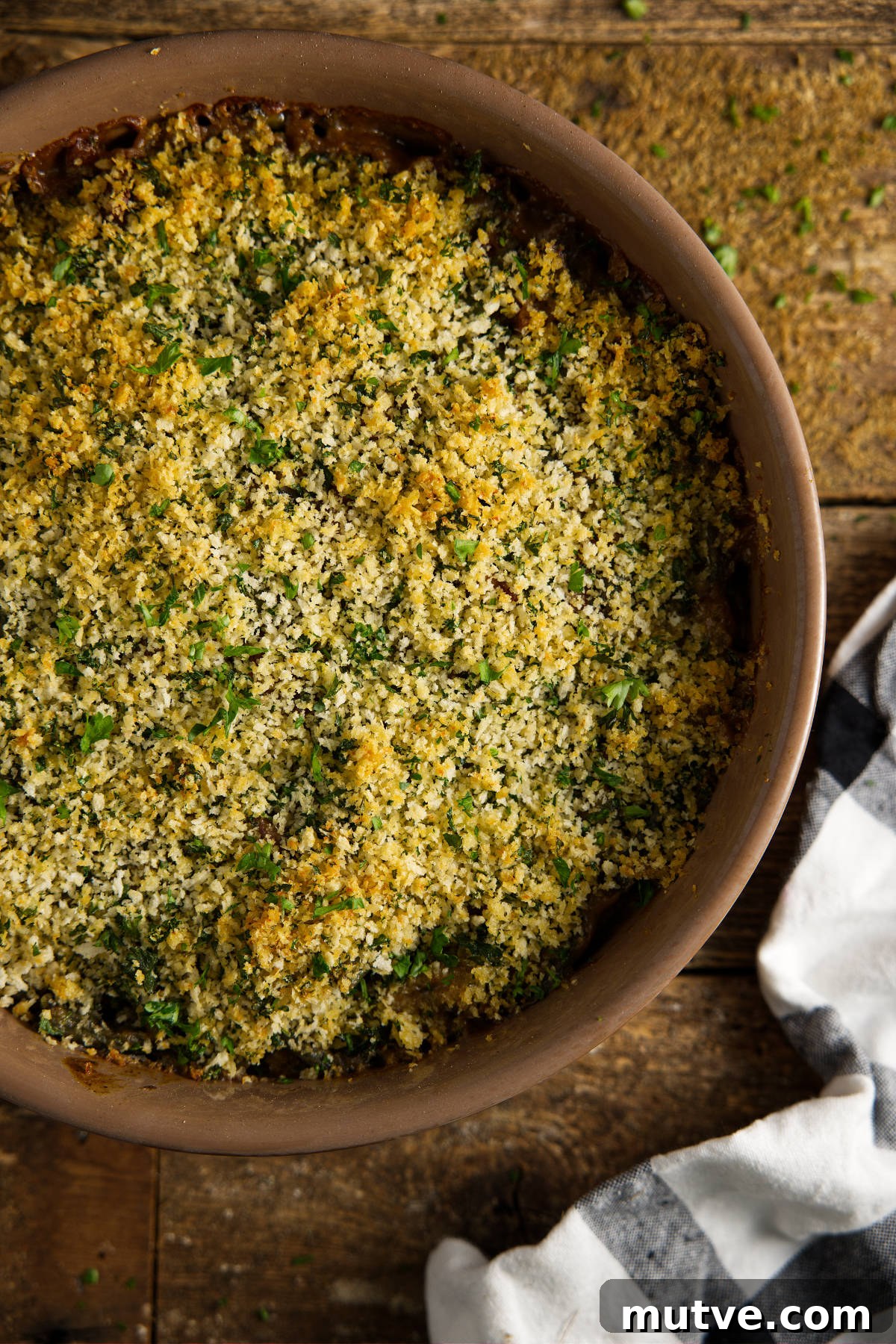 Overhead of green bean casserole, topped with an herb breadcrumb mixture and smoked until golden brown.