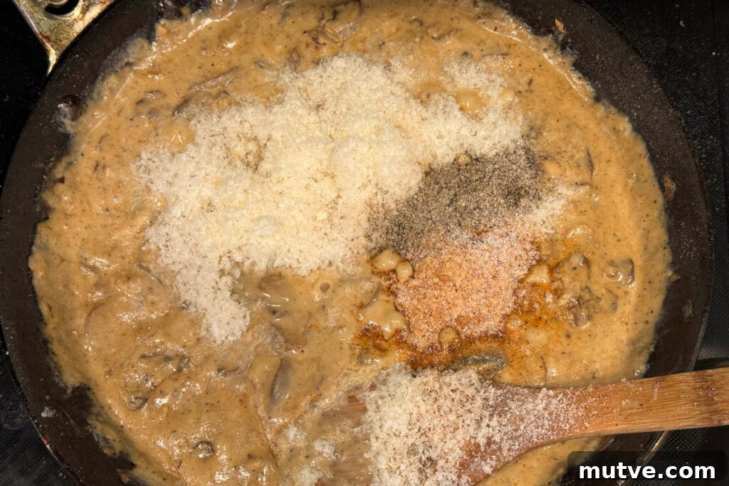 Adding parmesan cheese and spices to the roux.