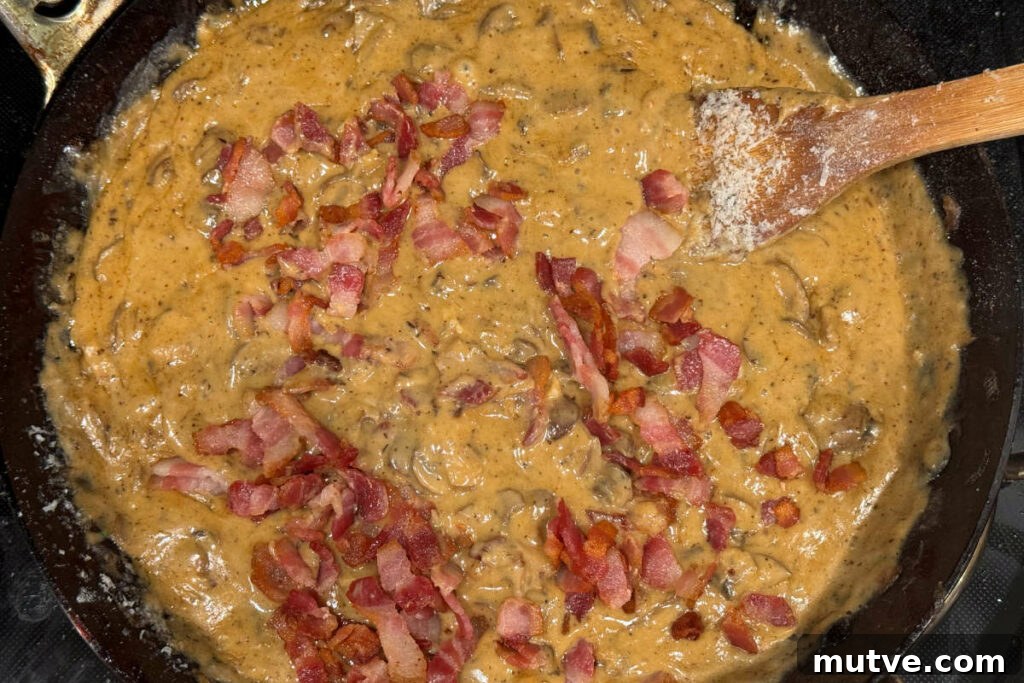 Adding bacon to the fry pan with the sauce for the green bean casserole.