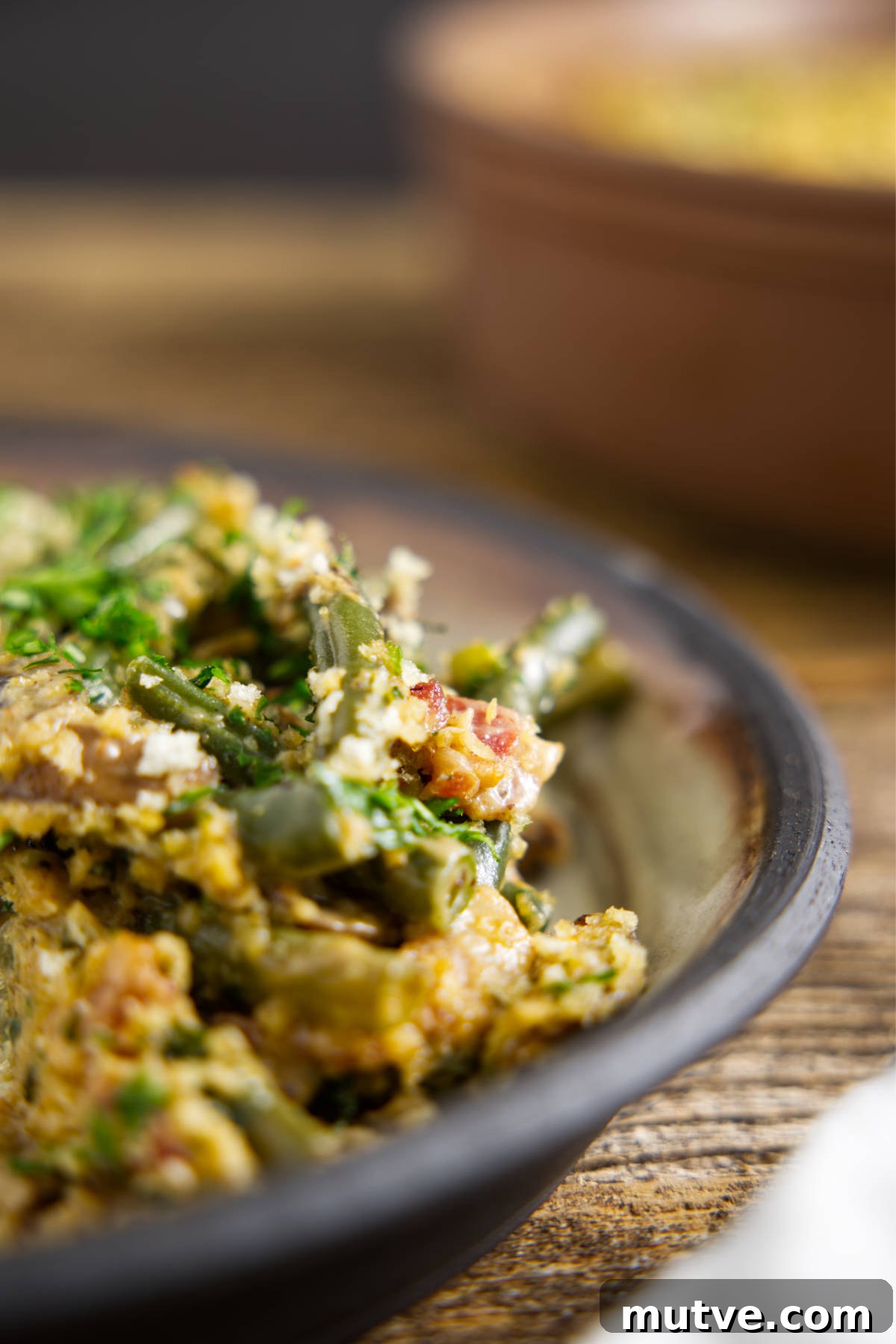 Green bean casserole plated on a white ceramic plate with black rim.