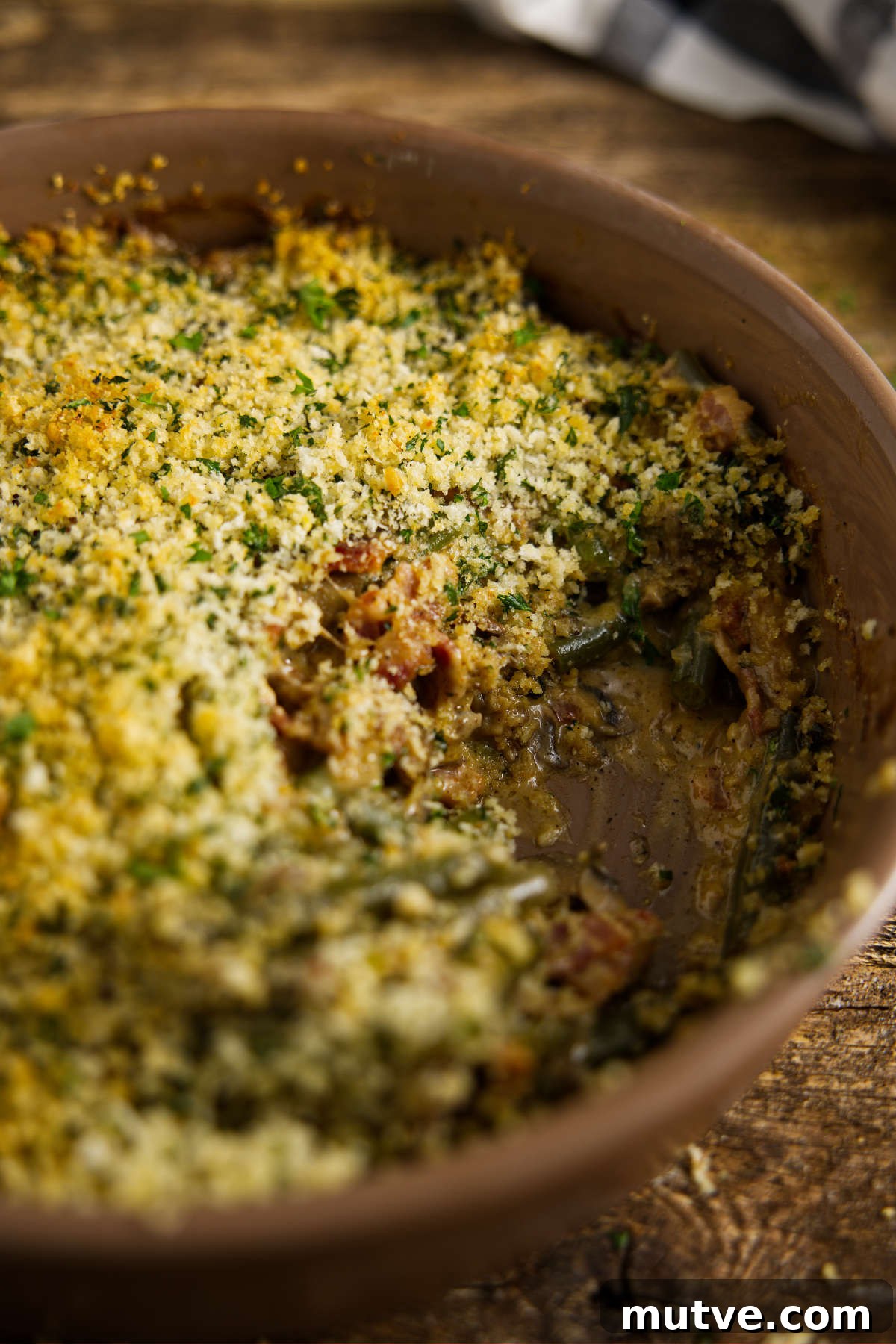 Scoop missing from casserole dish of smoked green bean casserole.