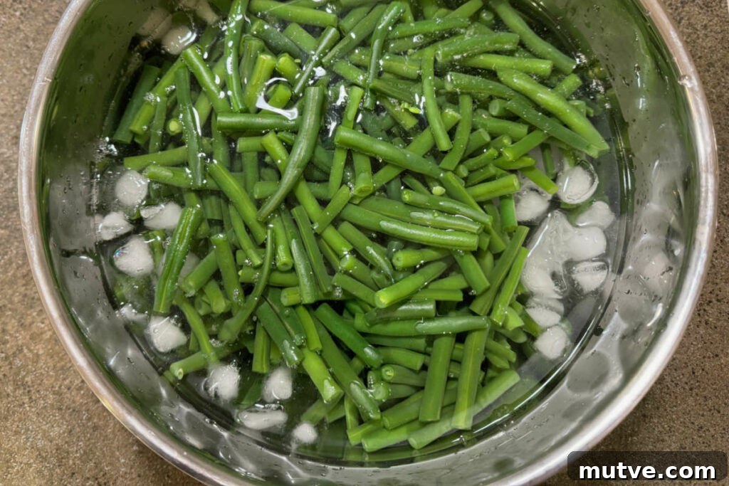 Tossing cooked green beans in an ice bath.