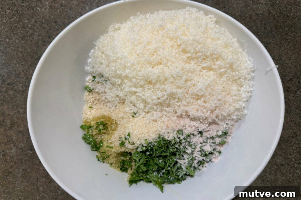 Combining cheese, herbs, oil, and seasoning to bread crumbs for the casserole topping.