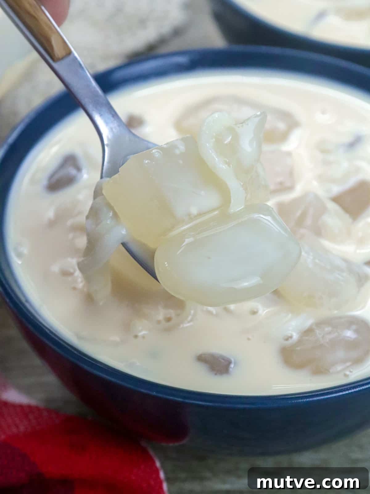 Creamy Buko Salad Recipe: Filipino Young Coconut Dessert 5 eating white buko salad with a spoon in a blue bowl