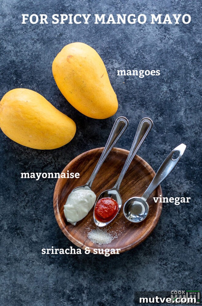 2 mangoes with spoons filled with mayonnaise, hot sauce, vinegar