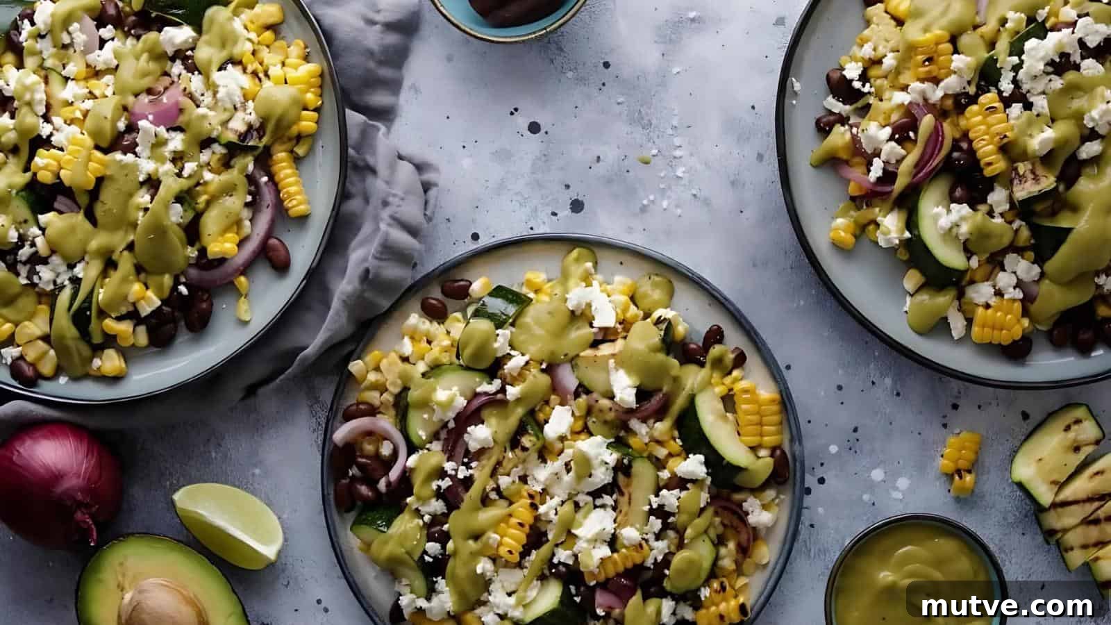 40 End-of-Summer Cookout Recipes to Celebrate Summer's Finale 24 Three plates of salad with corn, black beans, avocado, cucumber, red onion, cheese, and dressing on a gray surface, with lime wedges and extra dressing nearby.