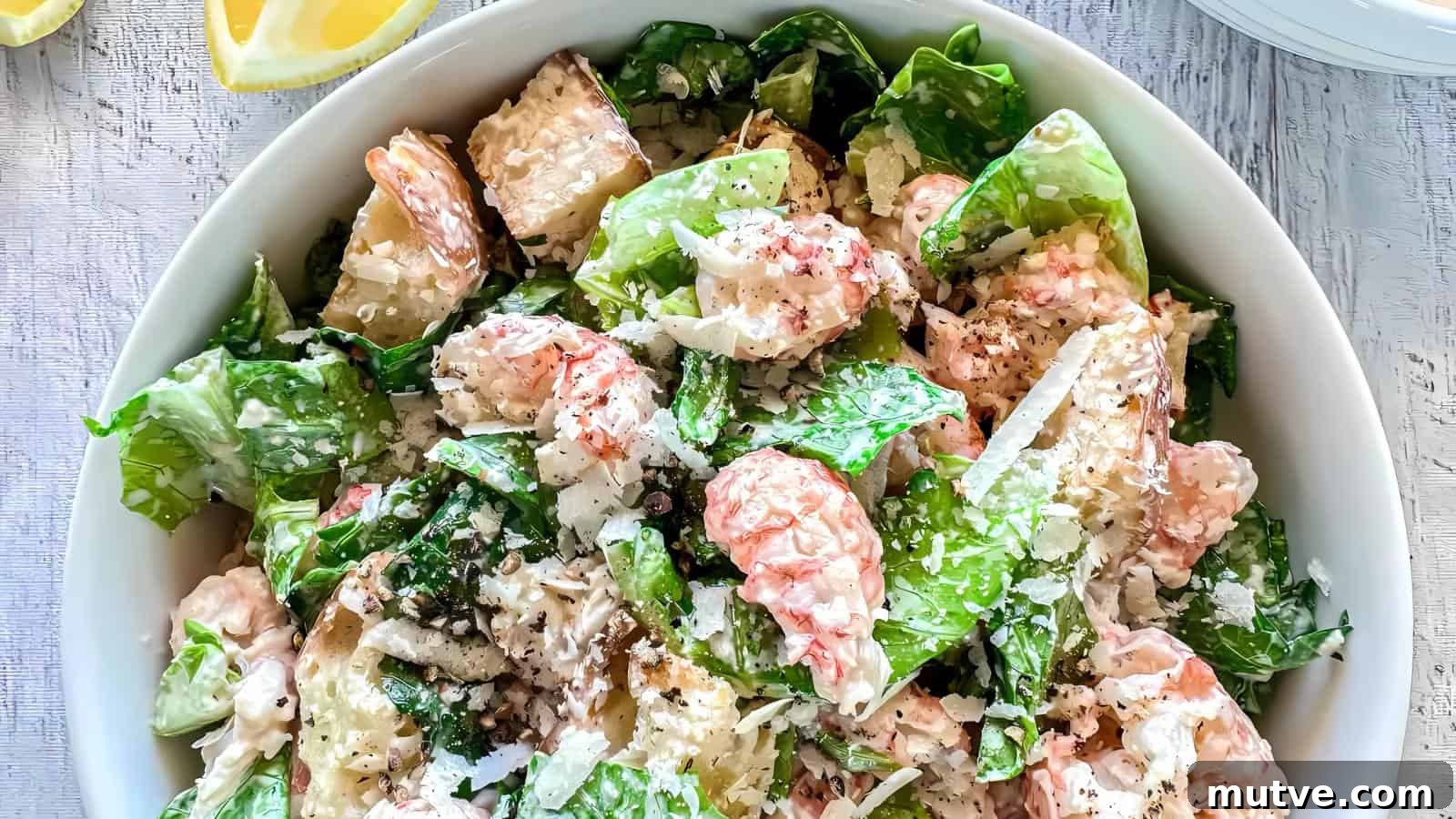 40 End-of-Summer Cookout Recipes to Celebrate Summer's Finale 25 A bowl of shrimp Caesar salad with romaine lettuce, shaved Parmesan cheese, and creamy dressing, garnished with ground black pepper.