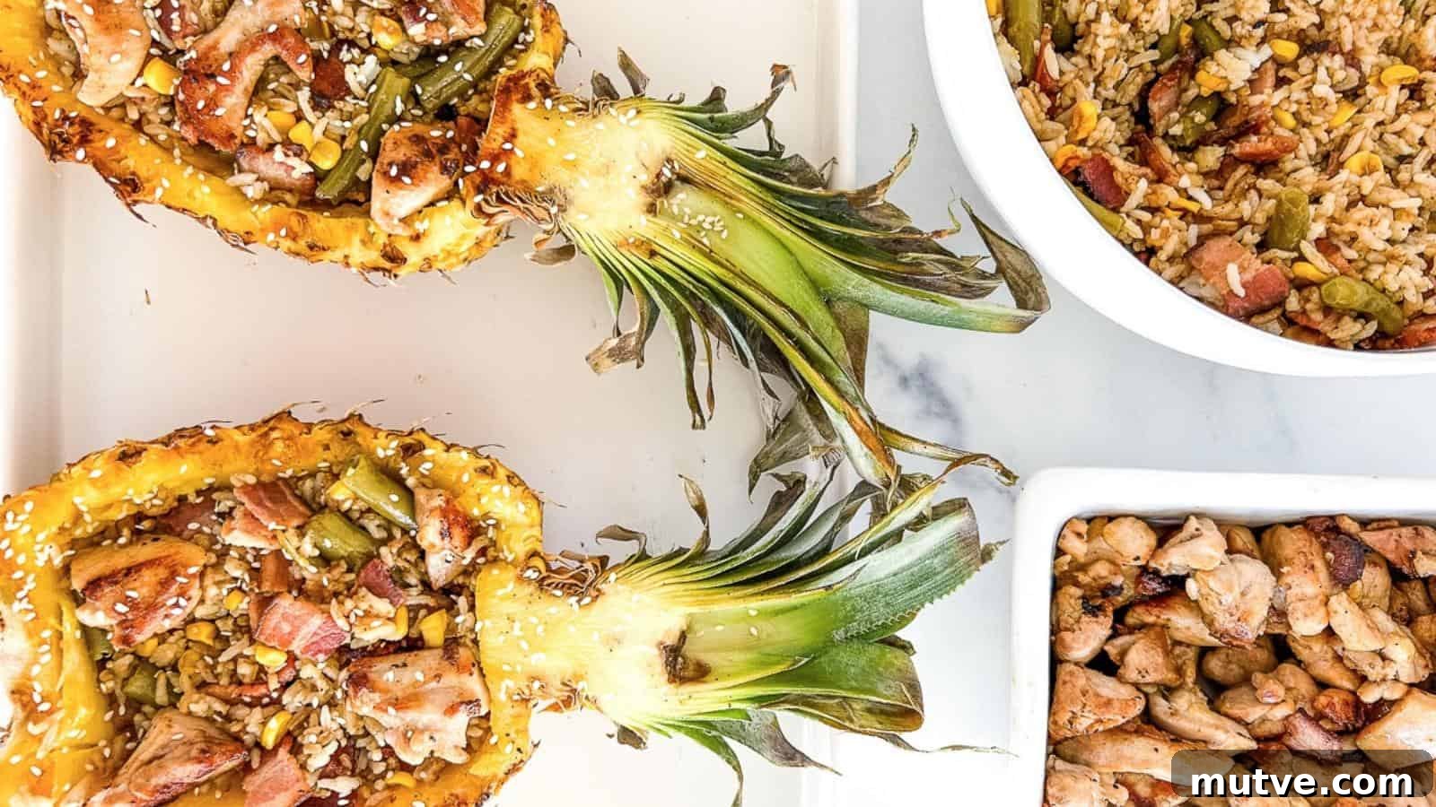 40 End-of-Summer Cookout Recipes to Celebrate Summer's Finale 40 Halved pineapples filled with chicken, vegetables, and rice, alongside bowls of fried rice and cooked chicken pieces on a white surface.
