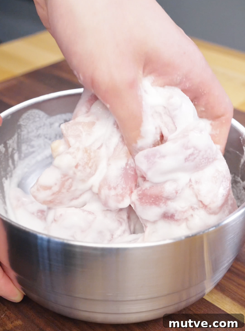 Raw chicken pieces being fully coated in a light batter mixture for the Honey Butter Fried Chicken Recipe.