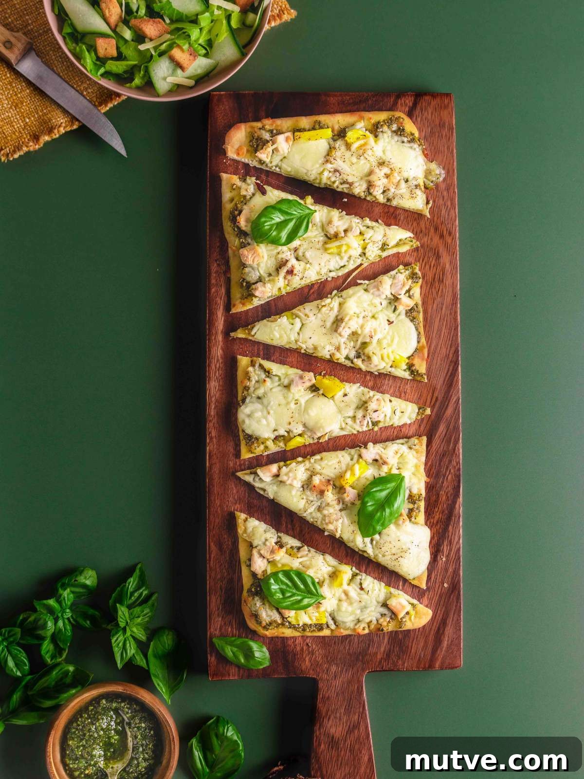 Pesto Chicken Flatbread Pizza Recipe 7 sliced pizza on a serving board.