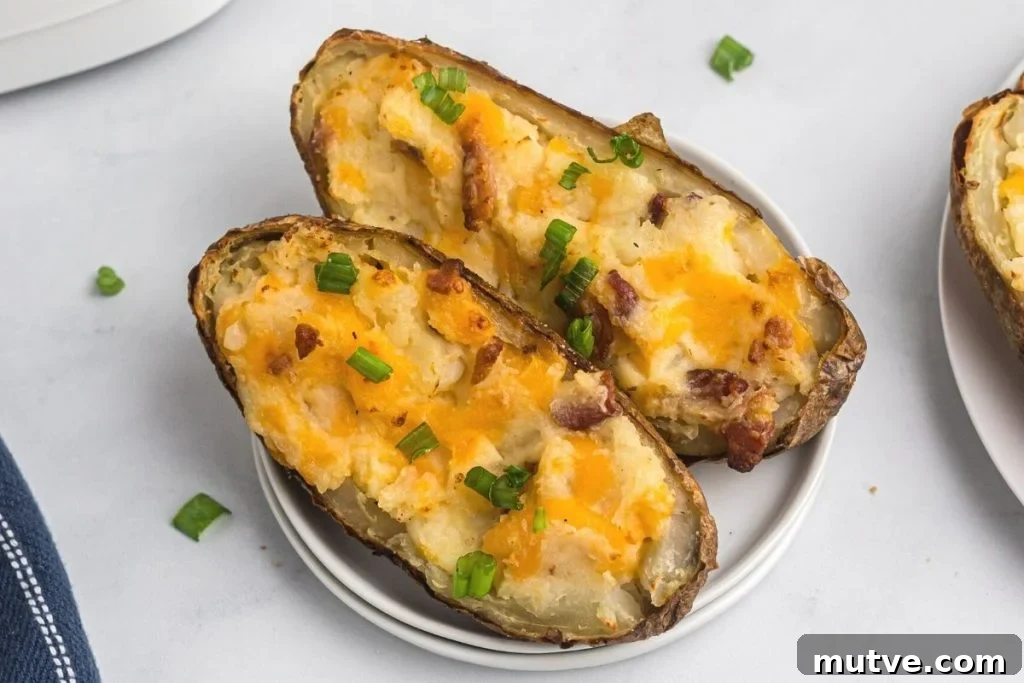 Twice baked filled potatoes in the air fryer served up on a white plate. 