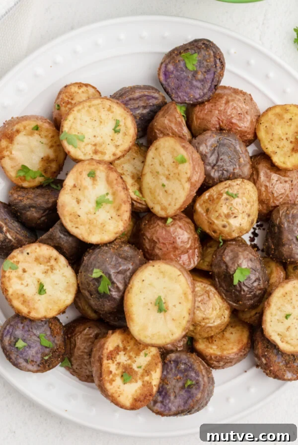 Air Fryer Roasted Potatoes in a white plate and garnished with fresh parsley. Ready to eat.
