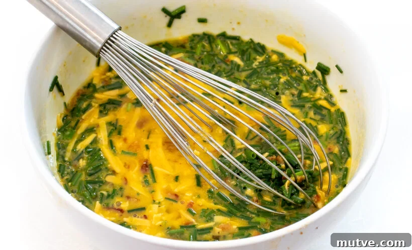 Bacon and Egg Breakfast Muffins Recipe 6 Eggs being whisked with chives, cheese and bacon.