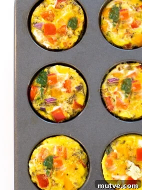 an overhead view of these easy egg muffin cups in a muffin tin with chopped peppers, onions, and spinach