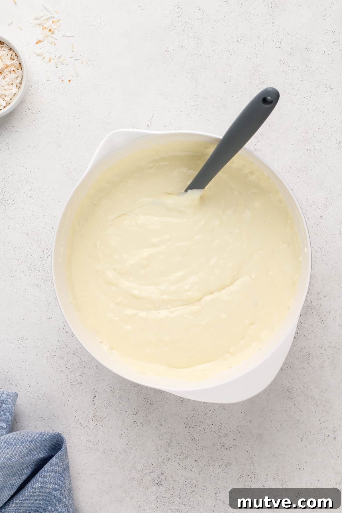 Creamy Coconut Cheesecake Recipe 9 Eggs mixed into coconut cheesecake batter.