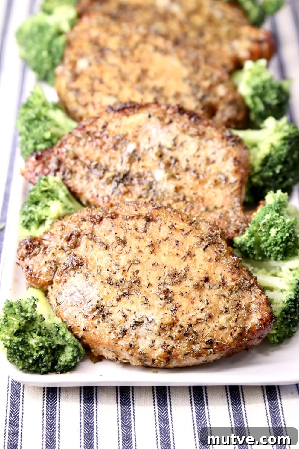 Onion Thyme Grilled Pork chops on a platter with broccoli spears