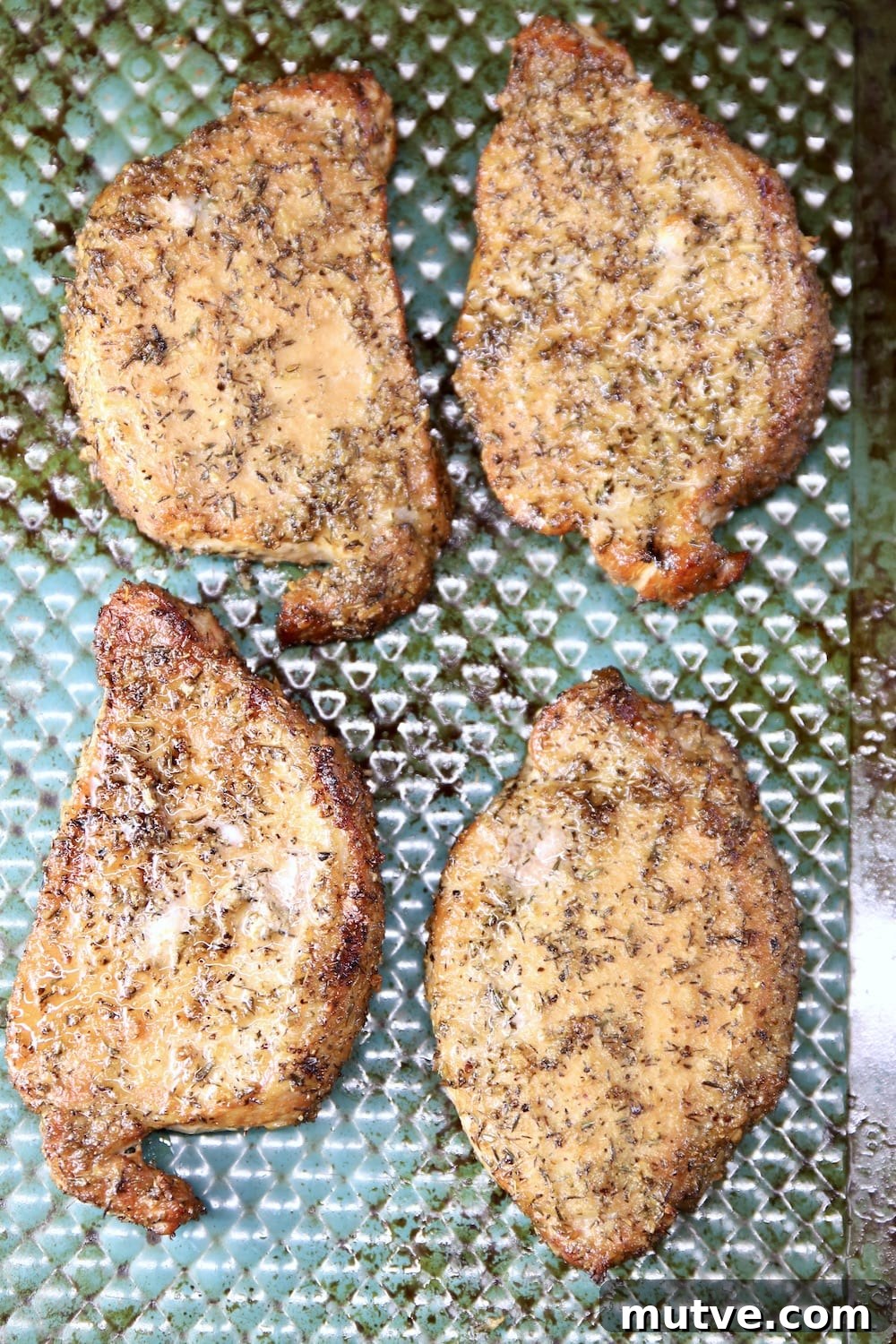 grilled pork chops on a blue sheet pan