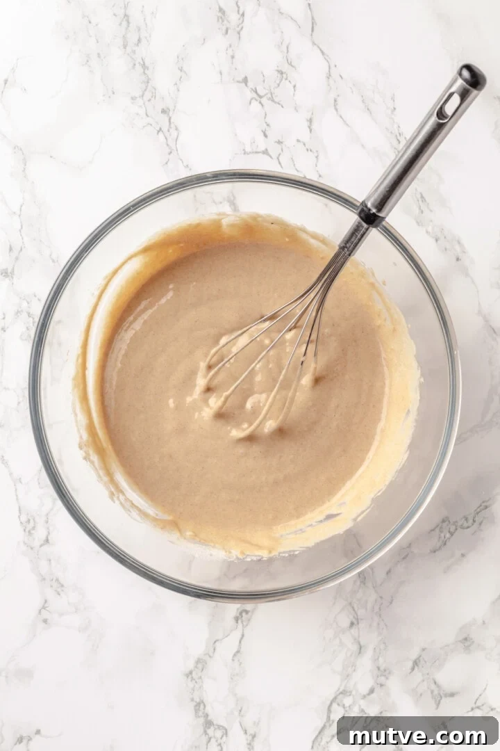 Overhead view of batter for protein pancakes in mixing bowl with whisk