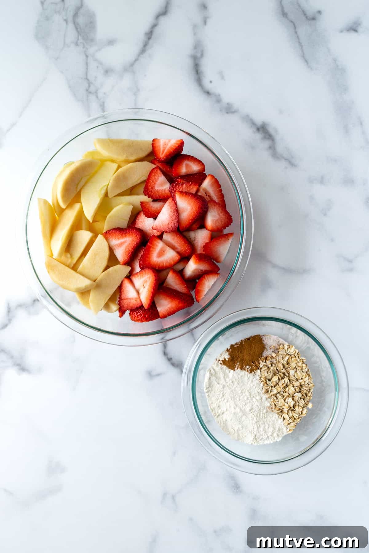 Warm Strawberry Apple Crisp Recipe with Cinnamon Oat Topping 4 two glass bowls with sliced strawberries and apples and crisp topping.